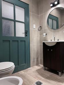 a bathroom with a green door and a toilet and a sink at Casa de Campo Ana María in Tupungato