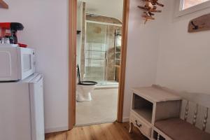 una cucina con forno a microonde e una porta per il bagno di l'Ecrin de l'Aa - Thalassa 2 a Grand-Fort-Philippe