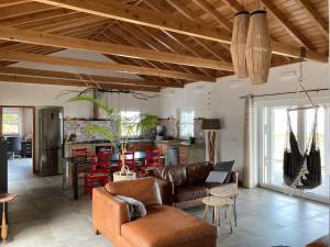 a living room with leather furniture and a kitchen at Pérola do Pico in Madalena