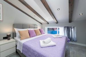 a bedroom with a purple bed with towels on it at Villa Dommy Gabby in Dubrovnik +73 photos