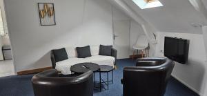 a living room with a couch and chairs and a tv at hotel terminus auray in Auray