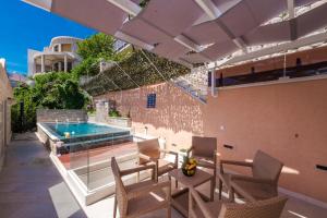 a patio with chairs and a swimming pool at Villa Dommy Gabby in Dubrovnik