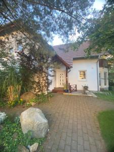 a small white house with a stone driveway at House Apartment am See in Markkleeberg