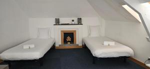 two beds in a room with a fireplace at hotel terminus auray in Auray