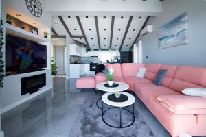 a living room with a pink couch and a tv at Villa Dommy Gabby in Dubrovnik