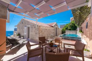 a patio with chairs and a table and a swimming pool at Villa Dommy Gabby in Dubrovnik