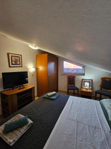 a bedroom with a bed and a flat screen tv at Sunset View Biograd in Biograd na Moru