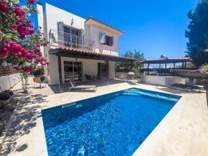 a villa with a swimming pool in front of a house at The Brilliant Villa in Protaras