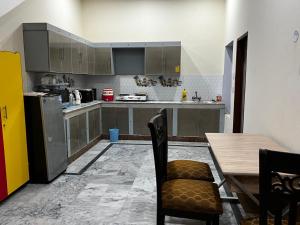 a kitchen with a wooden table and a table and chairs at House for Short Term Renting in Sargodha