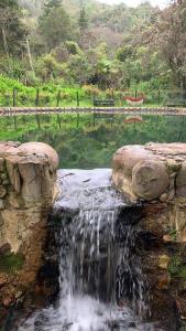 a waterfall in a pond with a bench in the background at Villa campestre San Vicente, Combita Boyacá in Cómbita +4 photos