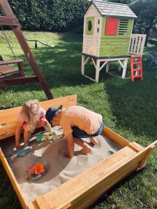 een jongen en een meisje spelen in een zandbak bij Apartament Leona in Ostrowo