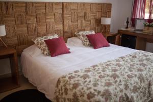 a bedroom with a large white bed with red pillows at Quinta da Sardinha in Elvas +65 photos
