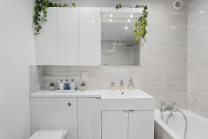 a white bathroom with a sink and a tub at Vomero Holiday Apartments in Torquay +261 photos