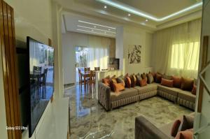a living room with two couches and a television at Villa Fares Assilah 2 in Asilah