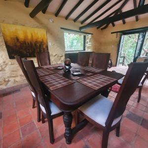 a dining room with a wooden table and chairs at Villa campestre San Vicente, Combita Boyacá in Cómbita