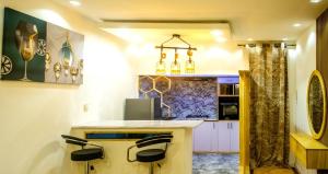 cocina con encimera y 2 taburetes en Villa avec Jacuzzi en Côte d'Azur, en Cotonou