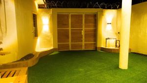 Una habitación con césped verde y una puerta con luces. en Villa avec Jacuzzi en Côte d'Azur, en Cotonou