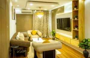 Una sala de estar con un sofá y sillas y un televisor. en Villa avec Jacuzzi en Côte d'Azur, en Cotonou