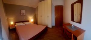 une petite chambre avec un lit et un miroir dans l'établissement MERY, à Poljica