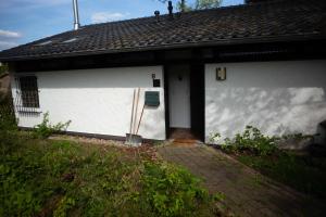 a white house with a door and a roof at Ferienhaus Eifelfreude in Lissendorf