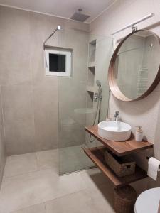 Un baño con ducha, lavabo y espejo. en Al Mare Apartments - 39, en Constanţa