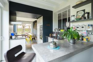 a kitchen with a counter and a dining room at OPARADI "La Villa Nature" - Parfaite pour les GROUPES in Belle-et-Houllefort