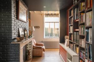 a living room with bookshelves and a window at OPARADI "La Villa Nature" - Parfaite pour les GROUPES in Belle-et-Houllefort