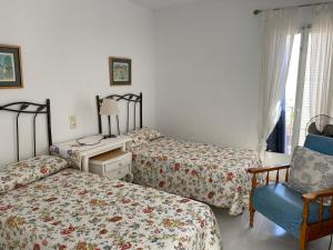 a bedroom with two beds and a desk and a chair at Casa Los Remos in La Marina de la Torre +21 photos