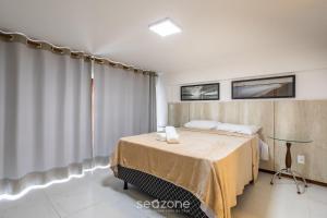 a bedroom with a bed and a glass table at CPR - Apartamentos a 200m da praia com Piscina in Marau