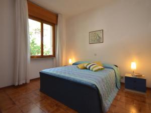 リニャーノ・サッビアドーロにあるVilla Missanaのベッドルーム1室(ランプ2つ、窓付)