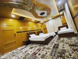a room with two beds and a ceiling with a tree on it at Alpine Resort Khaplu in Khaplu