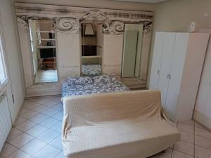 a bedroom with a large bed and a mirror at Spillo Short Rent Affitti brevi in Due Carrare
