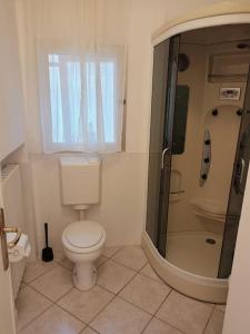 a bathroom with a toilet and a shower at Spillo Short Rent Affitti brevi in Due Carrare +3 photos