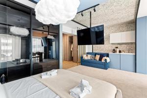 Cette chambre comprend un grand lit et un canapé bleu. dans l'établissement 5 Senses by Jorge - Infinity Pool & Spa Resort, à Mamaia Nord – Năvodari