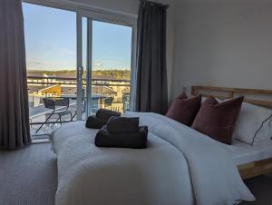 a bedroom with a large bed and a large window at Two Bedroom Duplex Apartment in Swansea