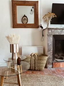 ein Wohnzimmer mit einem Glastisch und einem Kamin in der Unterkunft La petite Maison Rouge in Portel-des-Corbières