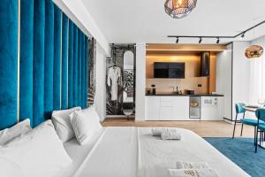 Cet appartement comprend une chambre avec un lit blanc et une cuisine. dans l'établissement 5 Senses by Jorge - Infinity Pool & Spa Resort, à Mamaia Nord – Năvodari