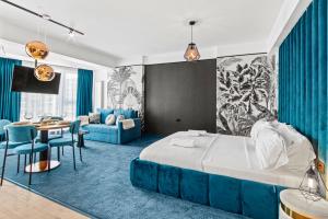 a bedroom with a large bed and a dining room at 5 Senses by Jorge in Infinity Pool & Spa Resort in Mamaia Sat/Năvodari