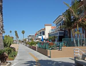 a street with houses and palm trees and a sidewalk at 1023 E Balboa B in Newport Beach