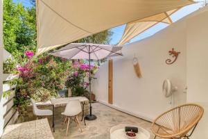 a patio with a table and chairs and an umbrella at The Tiny House in Parikia