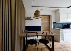 a kitchen with a wooden table and two chairs at Apart Alpine Retreat 2 in Fliess