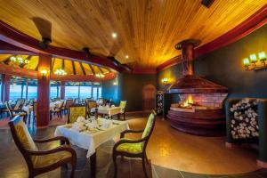 a restaurant with a fireplace and tables and chairs at Lake Nakuru Sopa Lodge in Nakuru