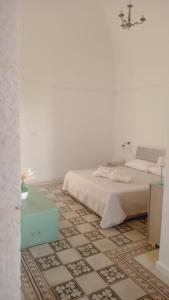 a white bedroom with a bed and a tiled floor at Villa Nuova 1924 in Mottola +22 photos