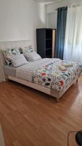 a bed in a bedroom with a wooden floor at Chambre Jardin 1 in Vaujours