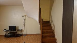 a staircase with a laptop on a table in a room at Chambre Jardin 1 in Vaujours