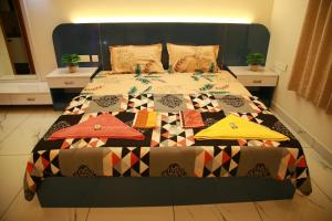a bedroom with a bed with a quilt on it at The Ample Appartment in Trivandrum