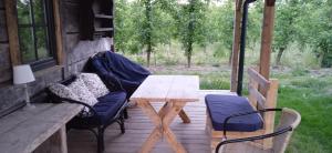 a wooden table and two chairs on a porch at Malwowo in Wilków