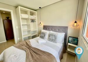 a bedroom with a bed with white sheets and pillows at N1204 Perfeito apto para férias e Beto Carrero! in Penha +62 photos