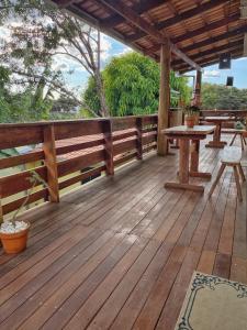 a wooden deck with tables and benches on it at Ypê Hospedagem in Sao Jorge