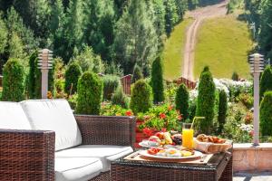 a table with a plate of food and a glass of orange juice at Hotel Yastrebets Wellness & Spa in Borovets